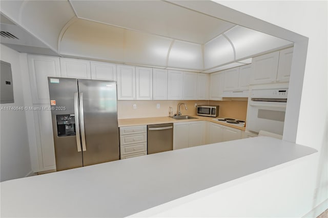 kitchen with stainless steel appliances, white cabinetry, sink, and kitchen peninsula