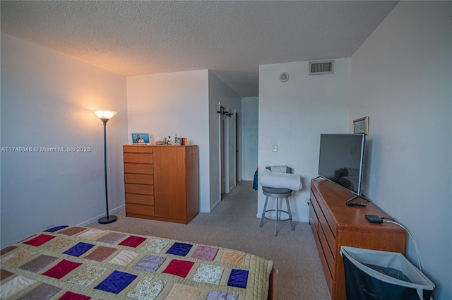 bedroom featuring light colored carpet and a textured ceiling