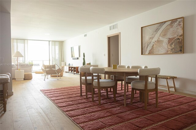 dining room with wood-type flooring and expansive windows