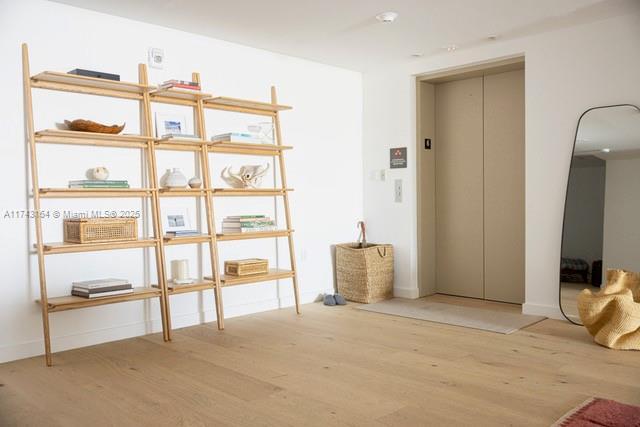 interior space with elevator and light wood-type flooring