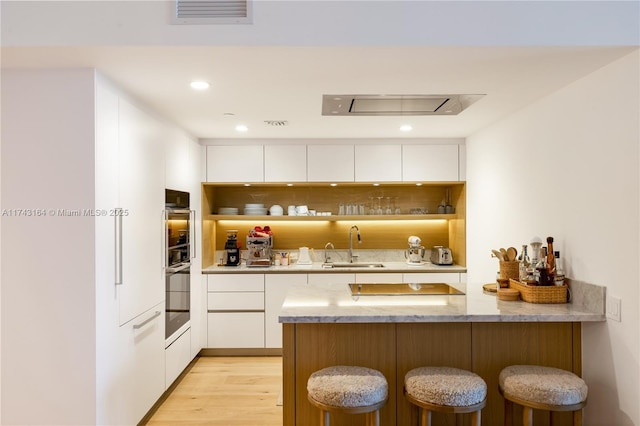 1135 103rd St Unit 602, Bay Harbor Islands, FL 33154 - kitchen featuring a peninsula, open shelves, a breakfast bar area, white cabinets, and recessed lighting