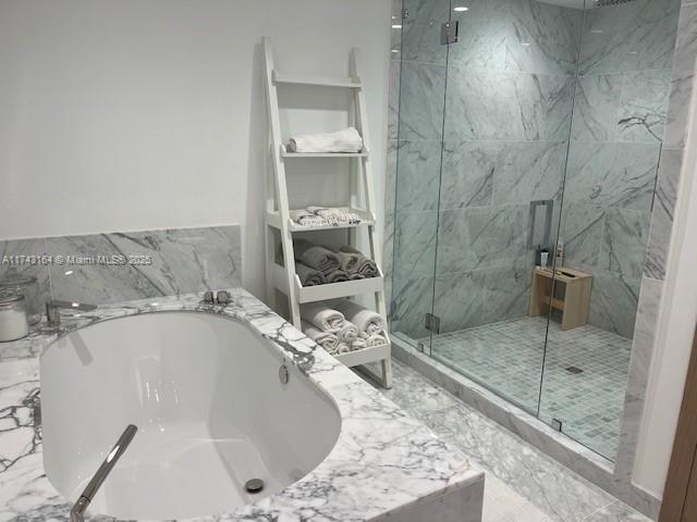 bathroom featuring shower with separate bathtub