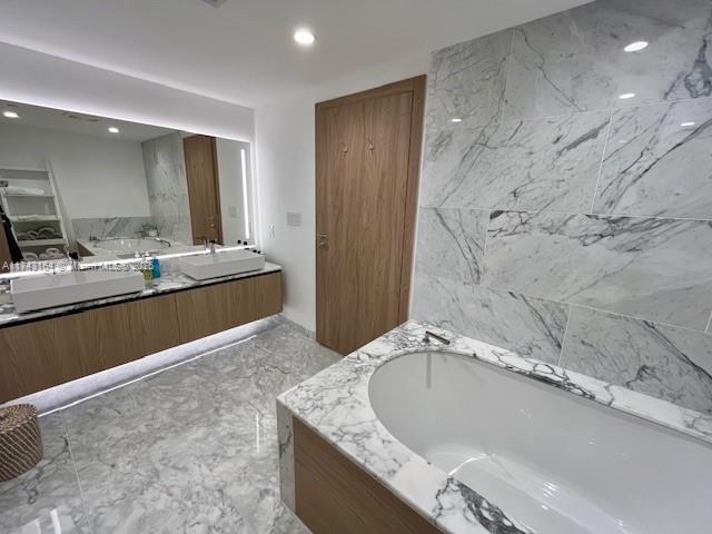 bathroom featuring vanity and a tub