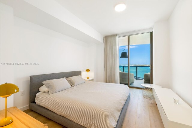 1135 103rd St Unit 602, Bay Harbor Islands, FL 33154 - bedroom with access to exterior, light wood-type flooring, and floor to ceiling windows