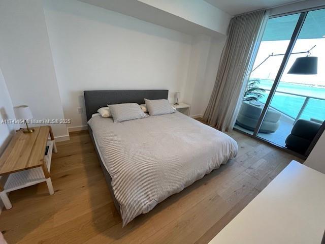 bedroom with hardwood / wood-style floors and access to exterior