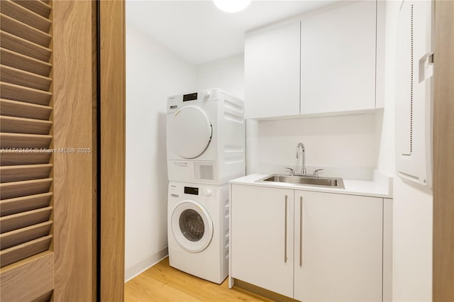 1135 103rd St Unit 602, Bay Harbor Islands, FL 33154 - laundry room featuring stacked washer / dryer, cabinet space, light wood-style flooring, and bar with sink
