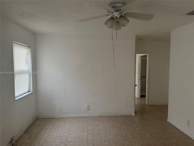 empty room featuring visible vents, a ceiling fan, a textured ceiling, and light tile patterned flooring