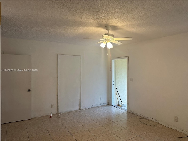 unfurnished room with ceiling fan, a textured ceiling, and light tile patterned floors