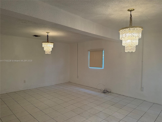 empty room featuring light tile patterned floors, visible vents, a textured ceiling, and an inviting chandelier