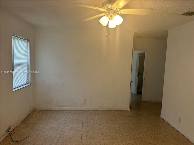 unfurnished room with light tile patterned floors, ceiling fan, visible vents, and a textured ceiling