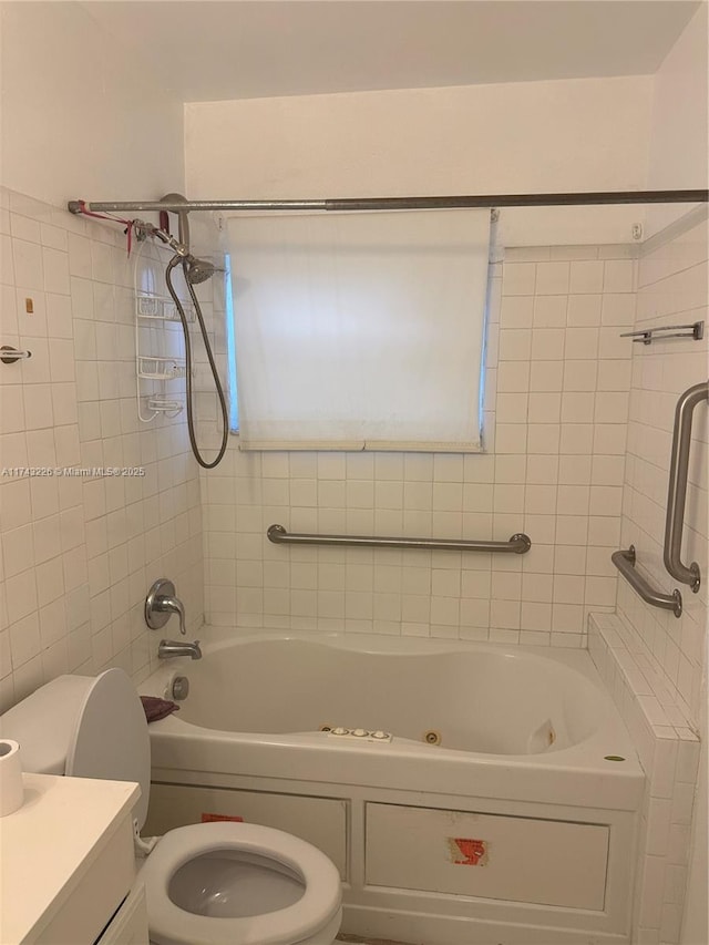 bathroom with a combined bath / shower with jetted tub, vanity, and toilet