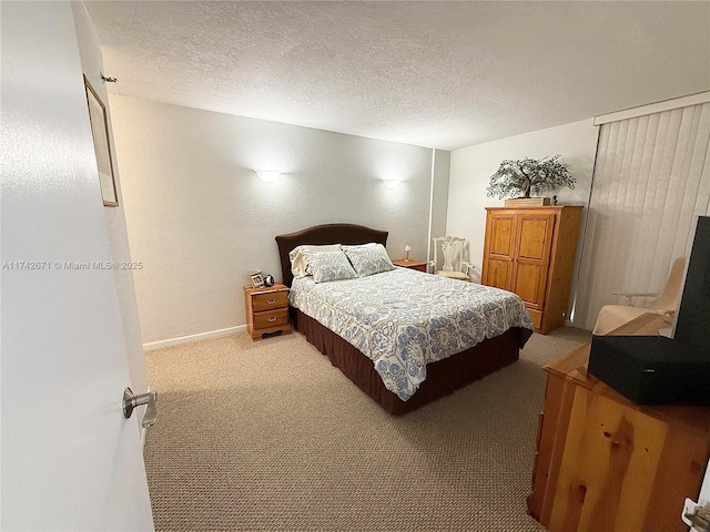 bedroom featuring light colored carpet and a textured ceiling