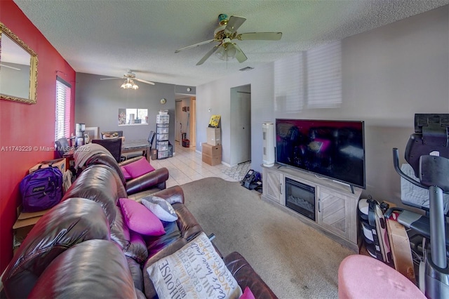 tiled living room with ceiling fan and a textured ceiling