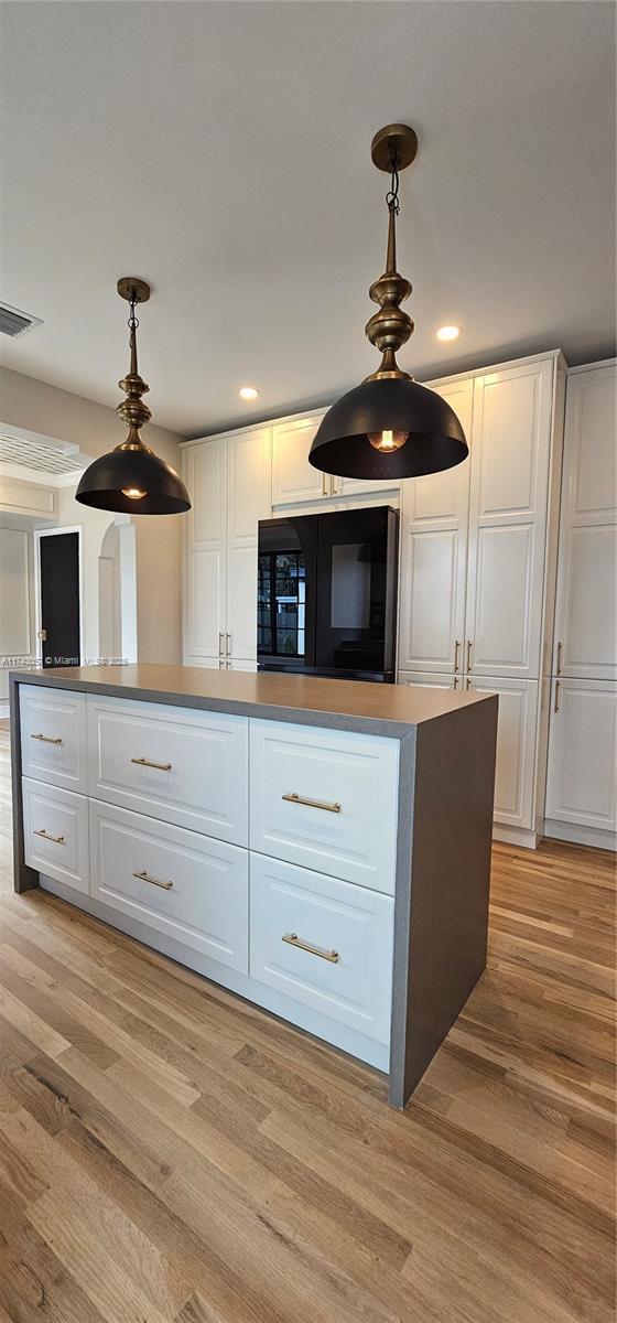 kitchen with recessed lighting, light wood-style flooring, pendant lighting, and white cabinetry