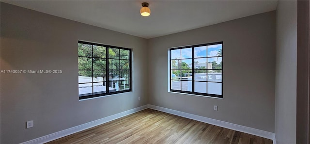 spare room with wood finished floors and baseboards