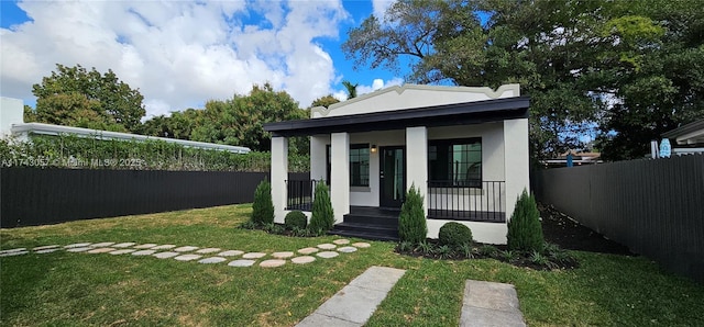 view of front of house with stucco siding, a porch, a front lawn, and fence