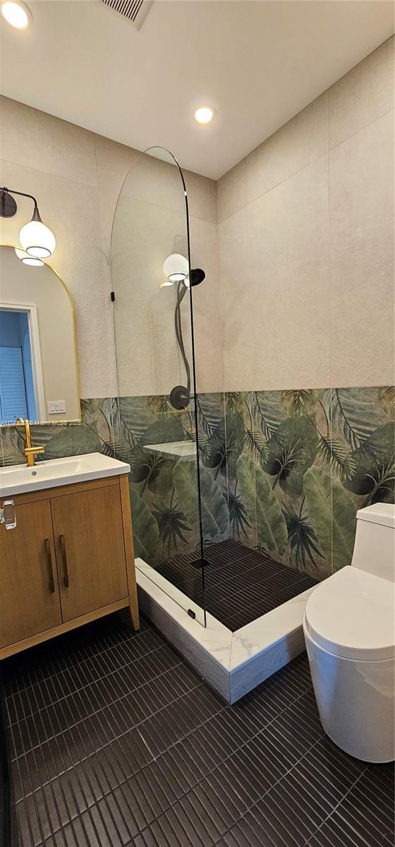 full bath featuring walk in shower, toilet, recessed lighting, tile patterned floors, and vanity