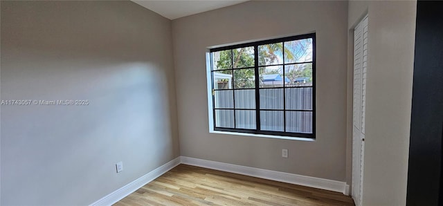 spare room with baseboards and light wood-style floors