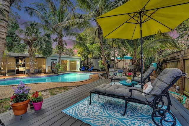 view of pool with a fenced in pool, fence, and a deck