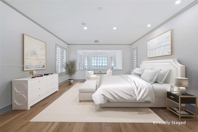 bedroom with crown molding and hardwood / wood-style floors