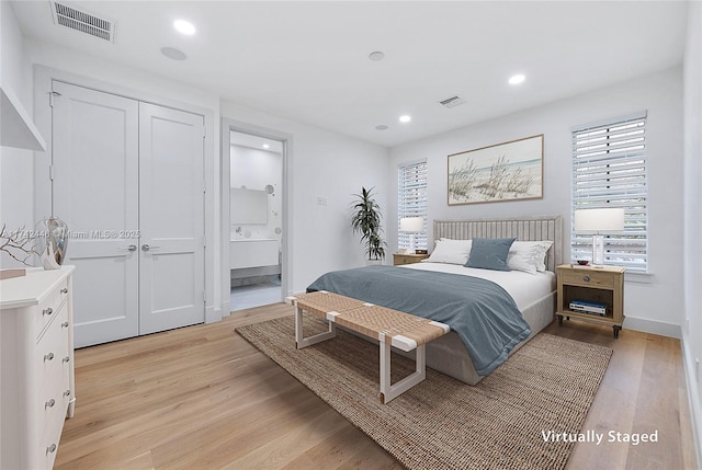 bedroom featuring connected bathroom and light wood-type flooring