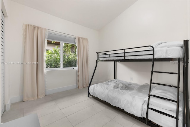 bedroom with lofted ceiling and light tile patterned floors