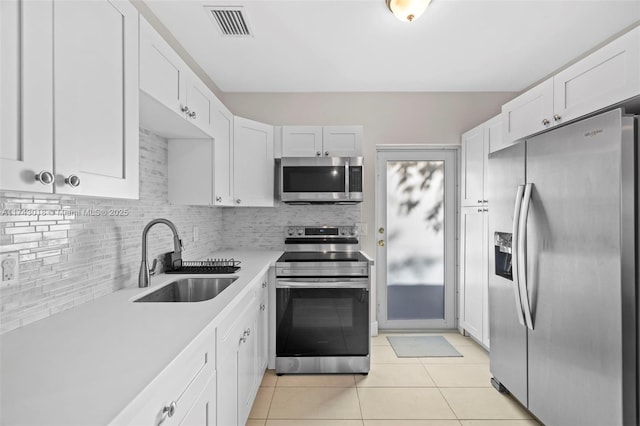 kitchen with white cabinetry, appliances with stainless steel finishes, sink, and decorative backsplash