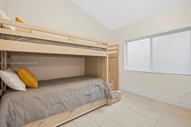 bedroom with tile patterned flooring and vaulted ceiling