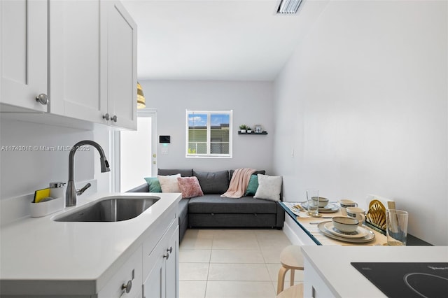 kitchen featuring white cabinetry, sink, and light tile patterned floors