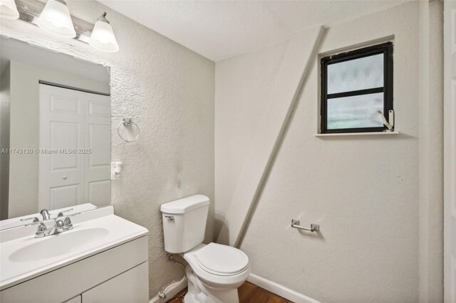 bathroom featuring hardwood / wood-style flooring, vanity, and toilet