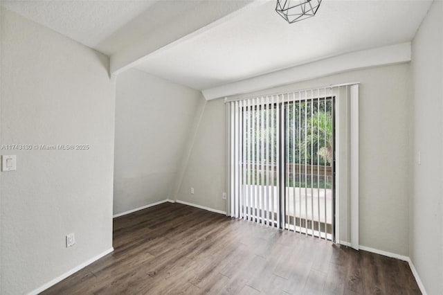 empty room with beam ceiling, hardwood / wood-style floors, and a textured ceiling