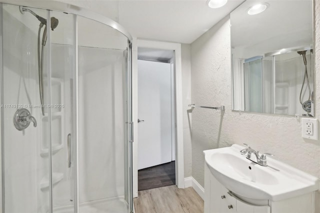 bathroom featuring vanity, hardwood / wood-style floors, and a shower with shower door