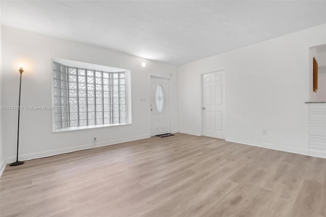 interior space with baseboards and light wood-style floors