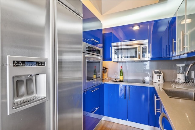 3101 Bayshore Dr Unit 1201, Fort Lauderdale, FL 33304 - kitchen with tasteful backsplash, appliances with stainless steel finishes, blue cabinetry, and sink