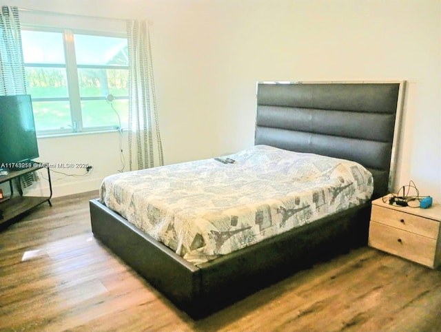 bedroom with baseboards and wood finished floors