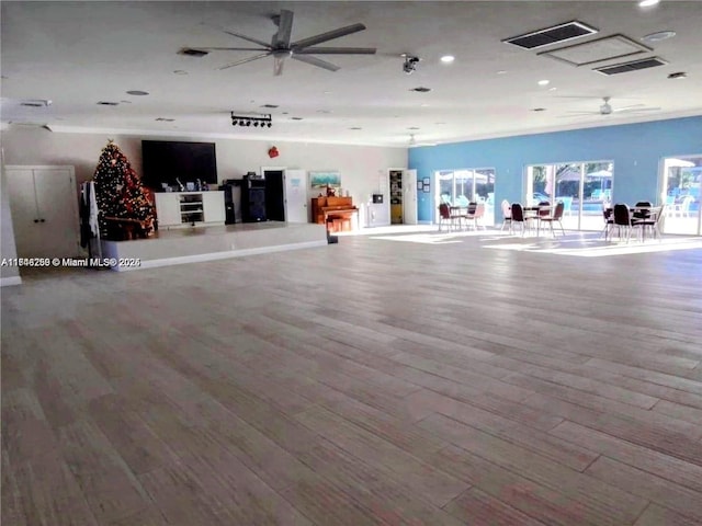 interior space with ceiling fan, visible vents, and wood finished floors