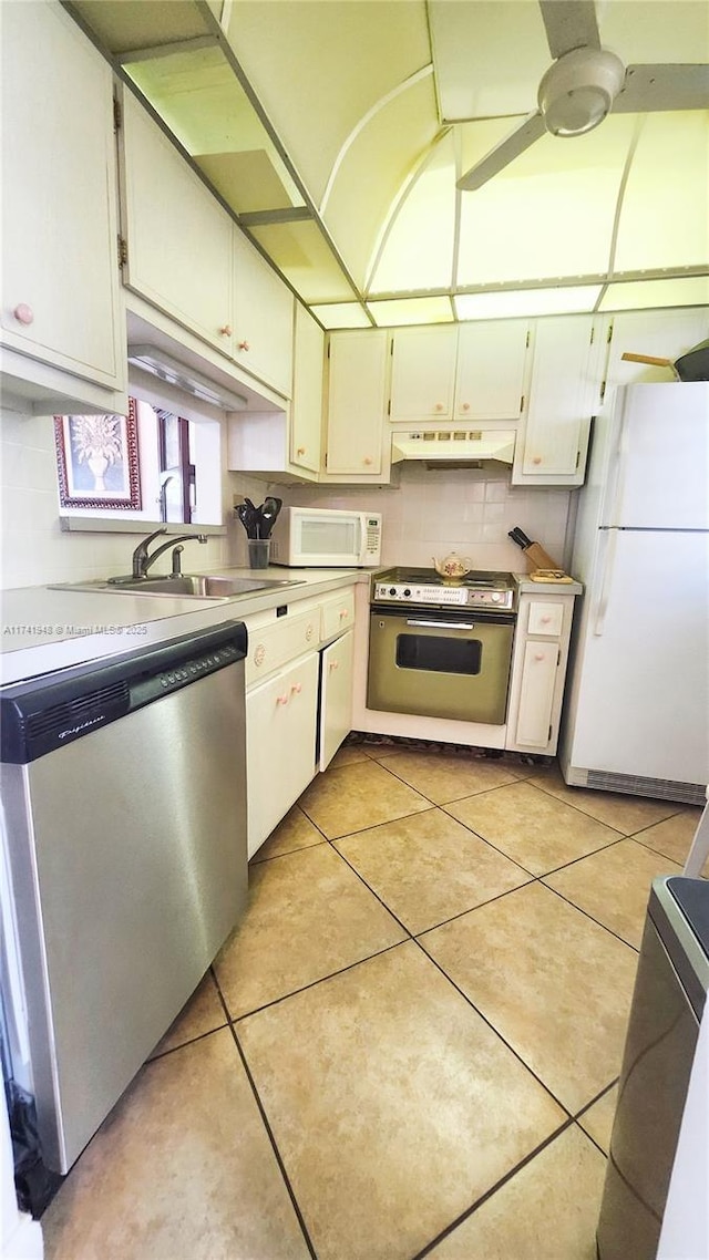 kitchen featuring light tile patterned flooring, white appliances, and white cabinets