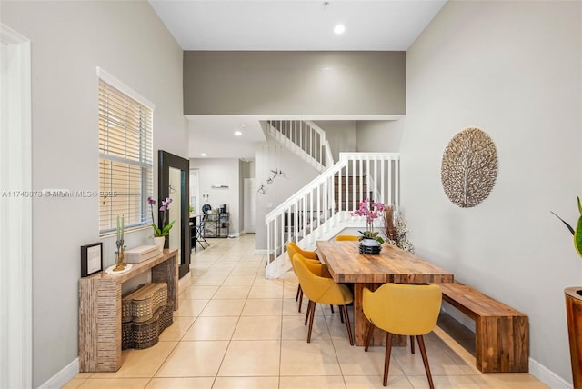 dining area with a towering ceiling and light tile patterned flooring