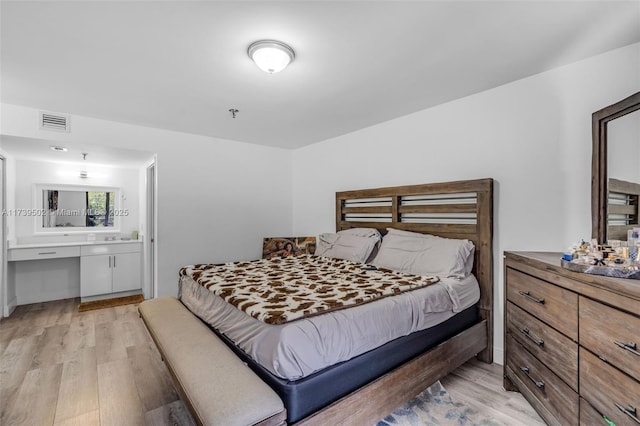 661 NE 195th St Unit 312, Miami, FL 33179 - bedroom featuring ensuite bathroom, built in desk, and light hardwood / wood-style flooring