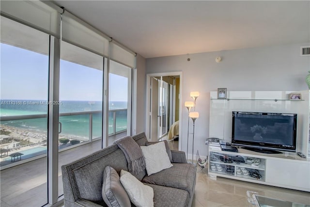 living room featuring a wall of windows and a view of the beach