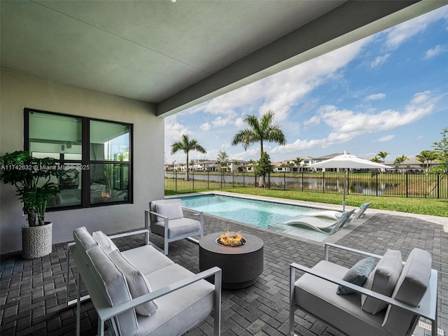 view of pool with an outdoor living space with a fire pit, a patio, and fence