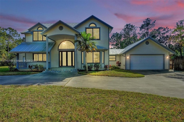 view of front of house with a yard, a garage, and a porch