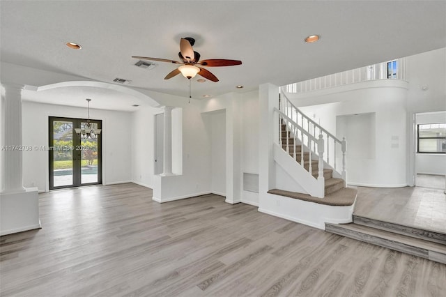 unfurnished living room with light hardwood / wood-style floors, decorative columns, ceiling fan, and french doors