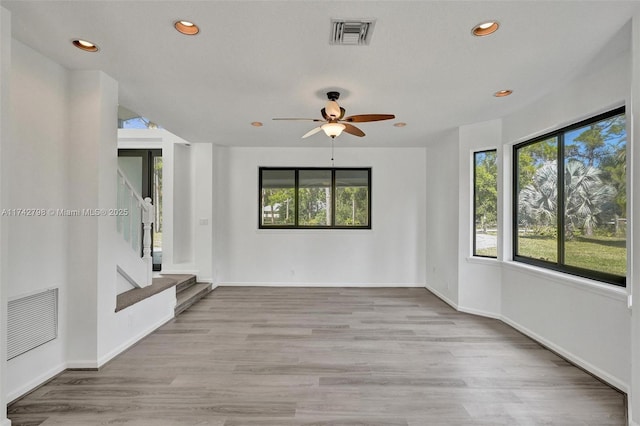 unfurnished living room with ceiling fan and light hardwood / wood-style flooring