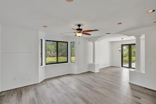 unfurnished room featuring ceiling fan, light hardwood / wood-style flooring, and ornate columns