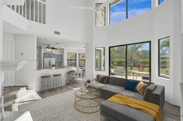 living room featuring ceiling fan, sink, and light hardwood / wood-style floors