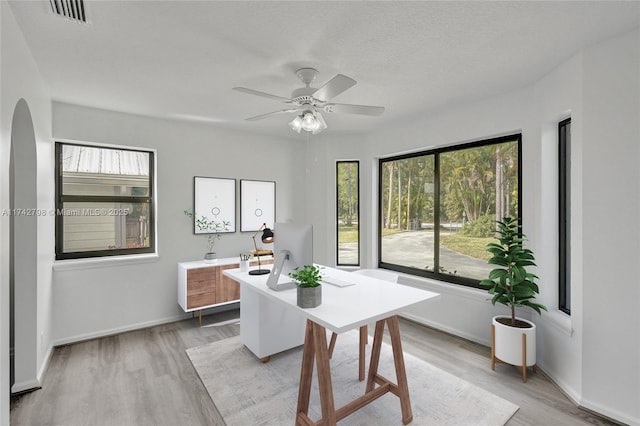 dining room with ceiling fan, a textured ceiling, and light wood-type flooring