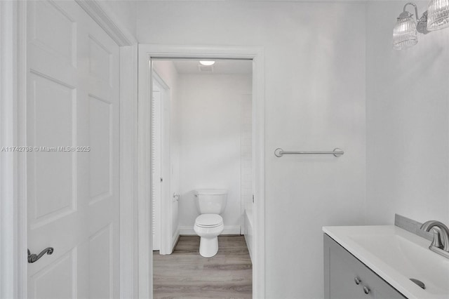 bathroom featuring vanity, wood-type flooring, and toilet