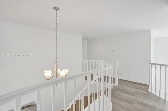 hall with hardwood / wood-style flooring and an inviting chandelier