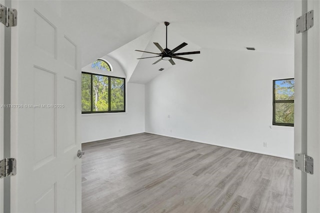 unfurnished room with vaulted ceiling, ceiling fan, and light wood-type flooring